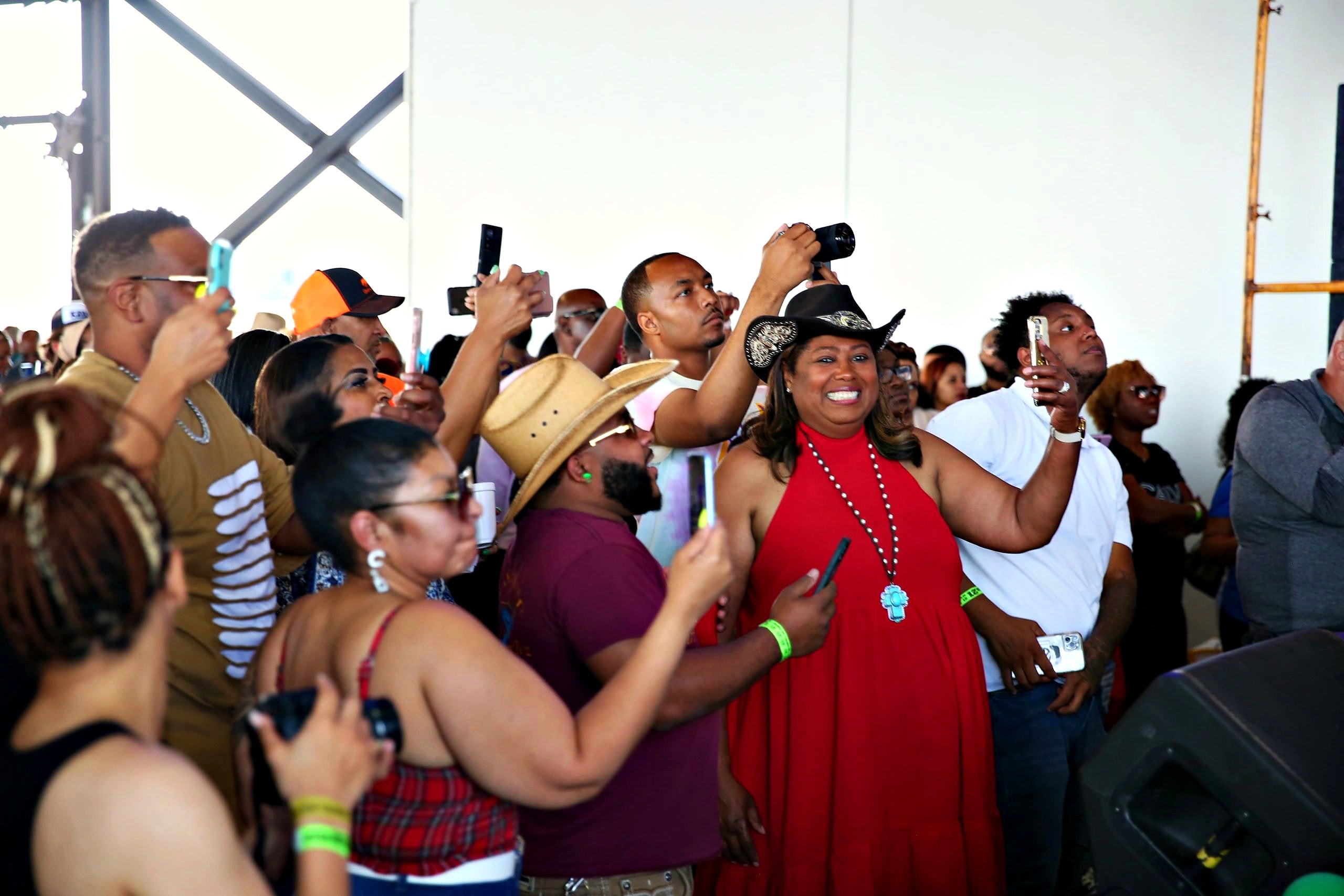 A packed crowd dancing under the open-air pavilion