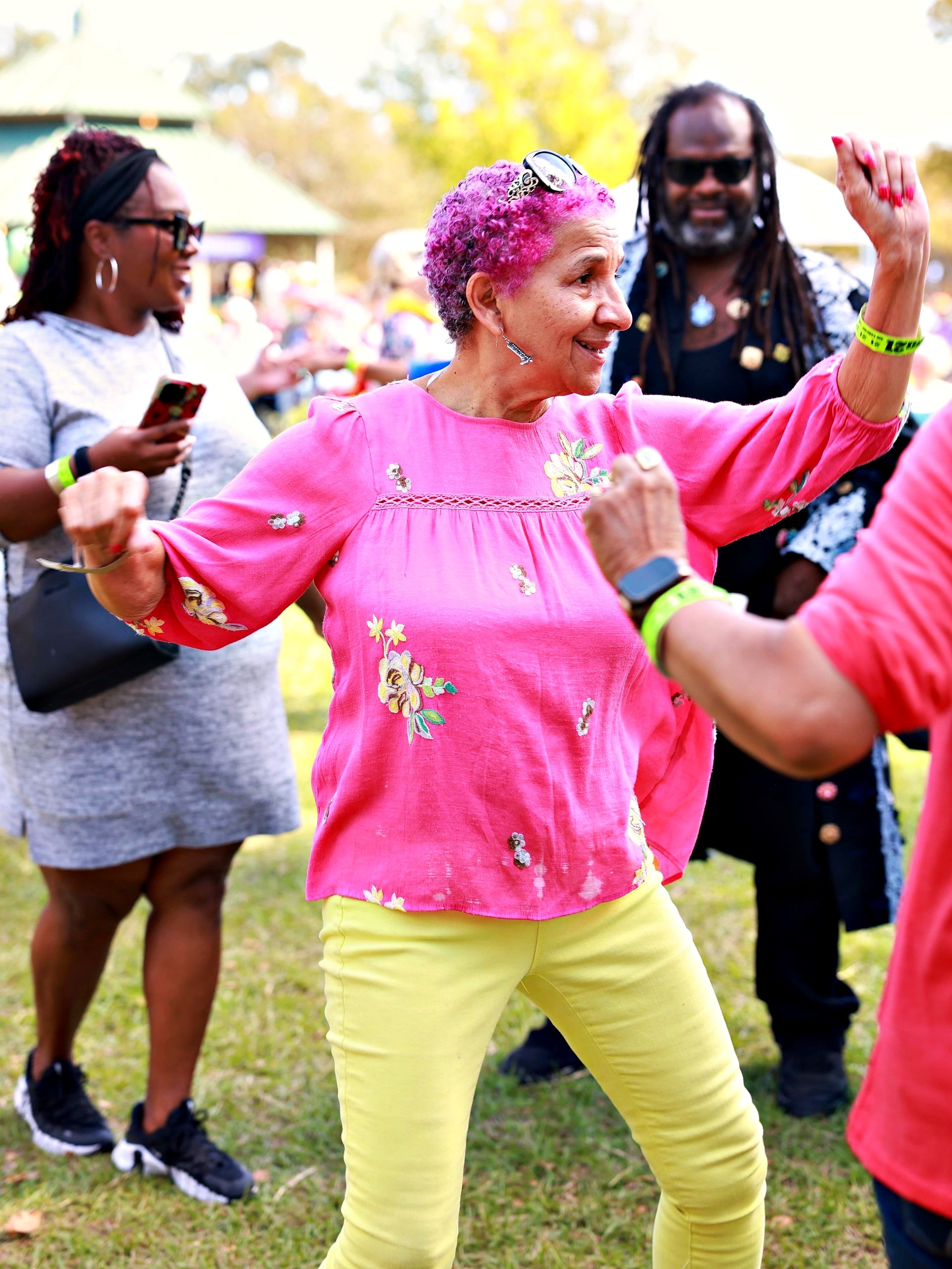 Festivalgoers dancing on the lawn in bright colors