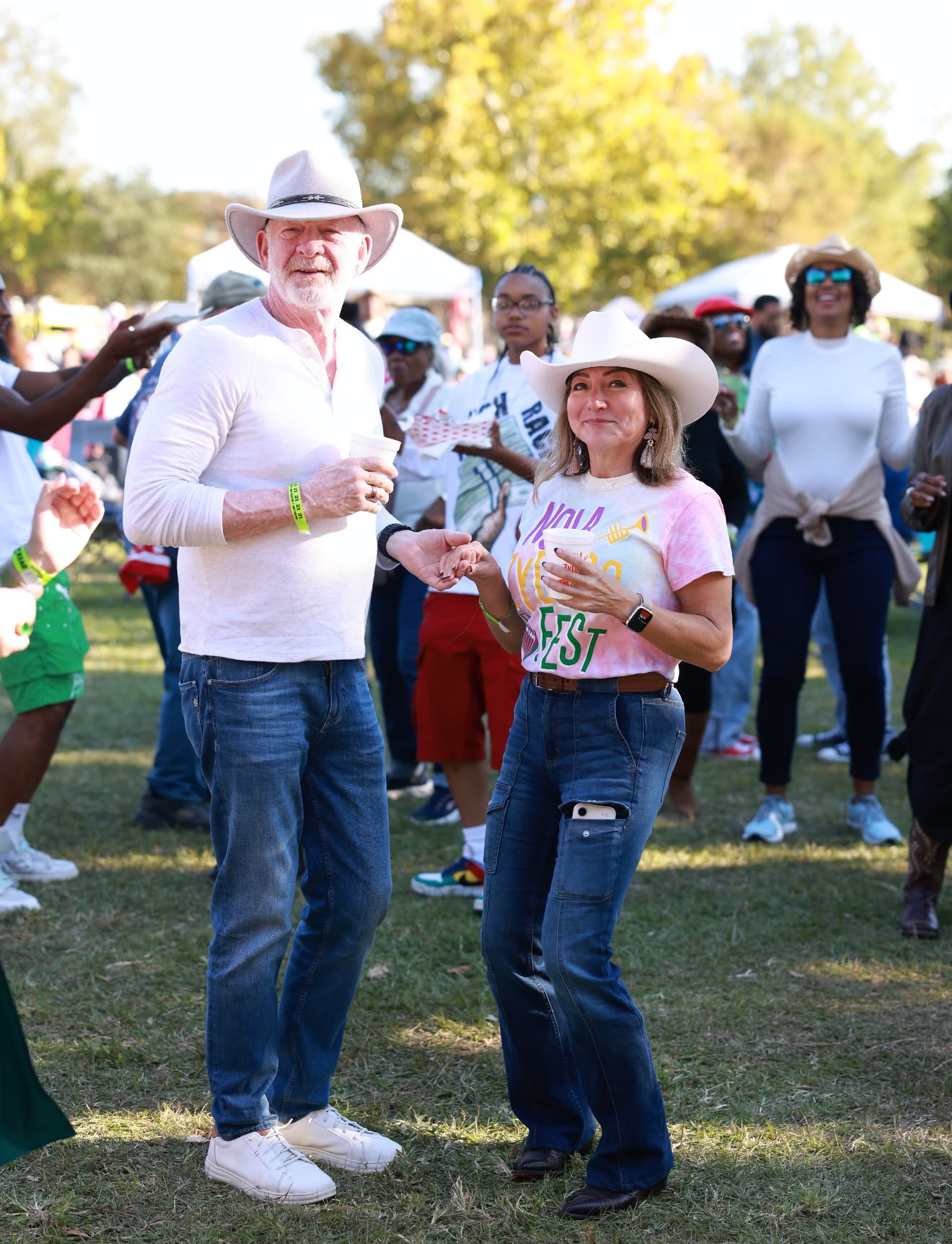A couple in cowboy hats dancing together on the lawn