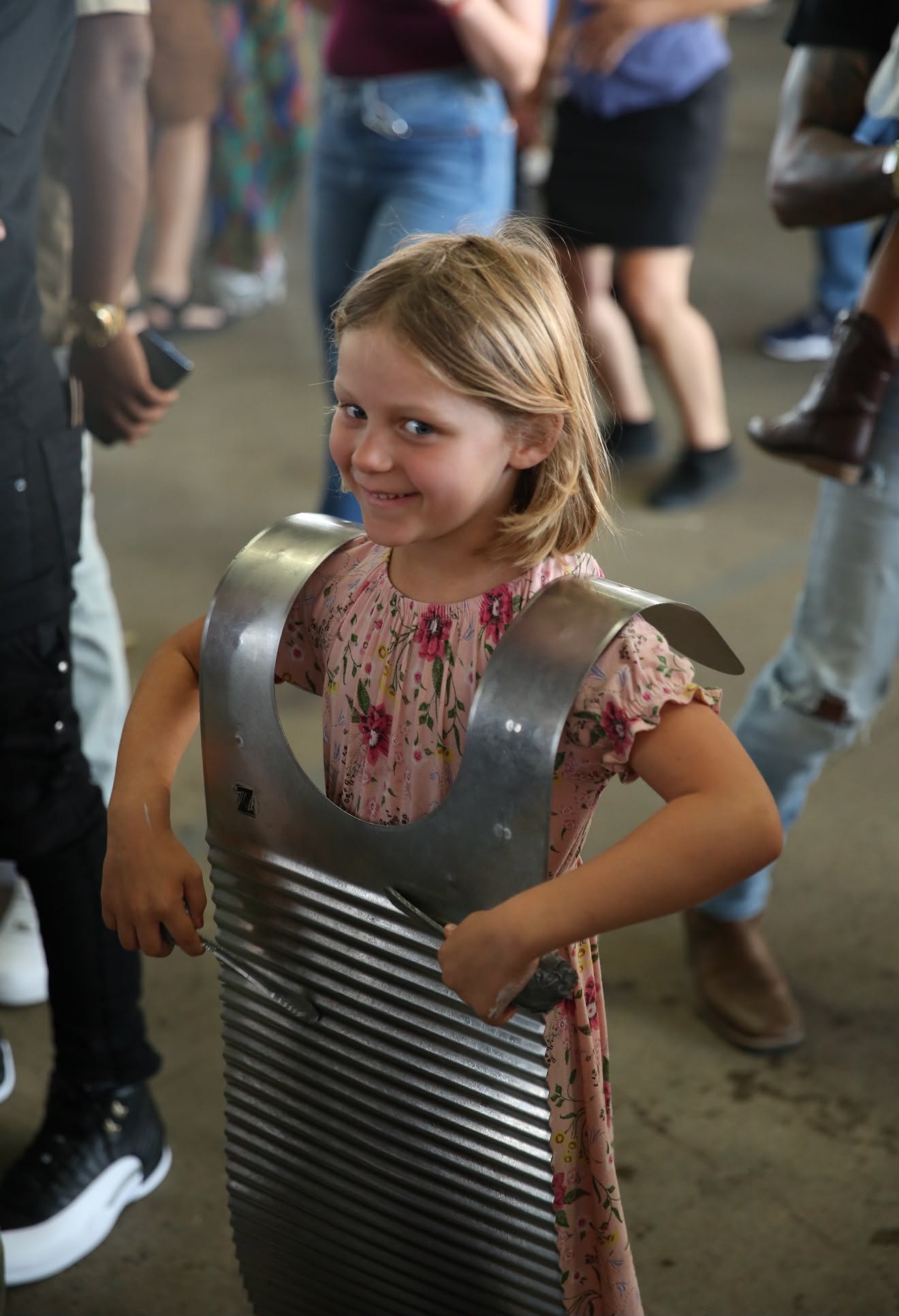 A young girl grinning while playing a rubboard
